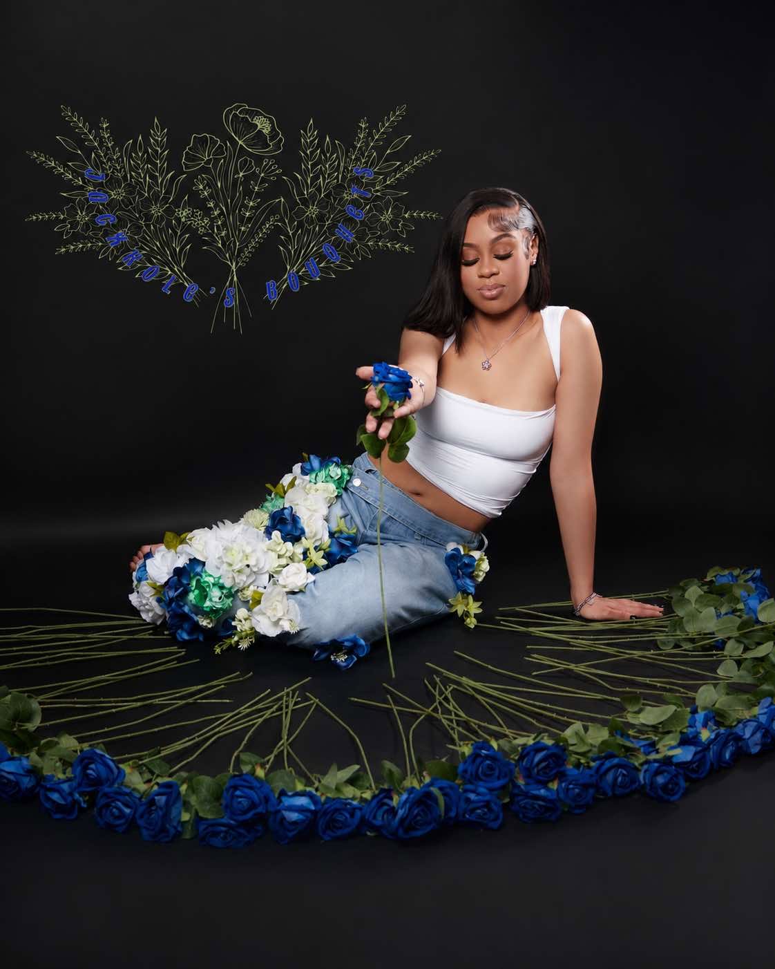 Editorial studio shot of Ja'Cole surrounded by blue and white roses